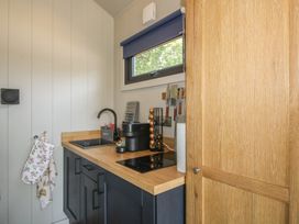 A kitchen with a sink and stove at Leafy Oaks Cabin in Munslow