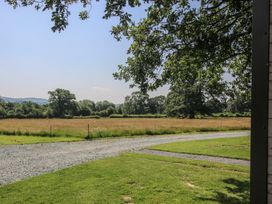 A view of an open field with trees at Leafy Oaks Cabin in Munslow