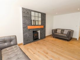 A living room with a fireplace and sofas at Bigting in Rhosneigr