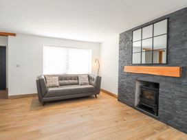 A living room with a sofa and fireplace at Bigting in Rhosneigr
