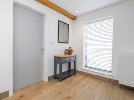 An entryway with a drawer unit and vases at Bigting Rhosneigr