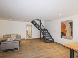 A living room with a staircase and wall art at Bigting in Rhosneigr