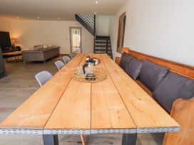 A dining room with a large wooden table and chairs at Bigting in Rhosneigr