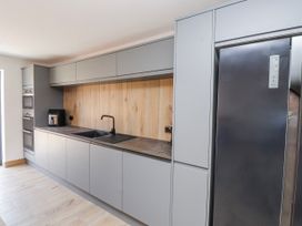 A kitchen with appliances and cabinets at Bigting in Rhosneigr
