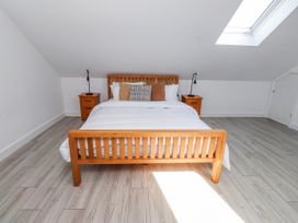 A bedroom with a bed and nightstands at Bigting in Rhosneigr