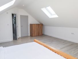 A bedroom with a bed and wardrobe at Bigting in Rhosneigr