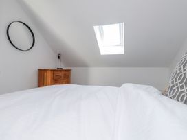 A bedroom with a bed and dresser at Bigting in Rhosneigr