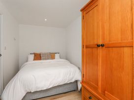 A bedroom with a bed and a wardrobe at Bigting in Rhosneigr