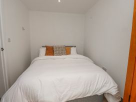 A bedroom with a bed and cushions at Bigting in Rhosneigr