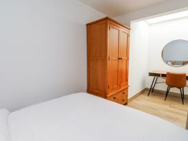 A bedroom with a bed, wardrobe, desk, and chair at Bigting in Rhosneigr
