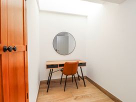 A study with a desk and chair and a mirror at Bigting in Rhosneigr