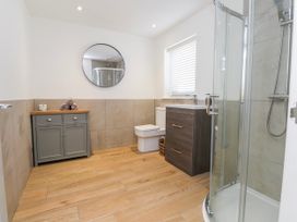 A bathroom with a shower, sink, and toilet at Bigting in Rhosneigr
