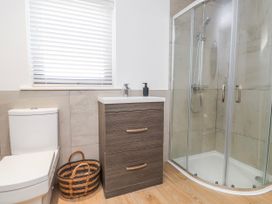 A bathroom featuring a toilet, shower, and vanity unit at Bigting in Rhosneigr