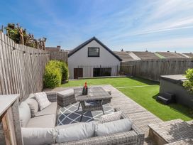 A garden with a sofa and coffee table at Bigting in Rhosneigr