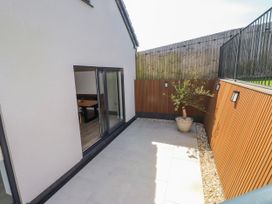 A patio area with a potted plant and a glass door at Bigting in Rhosneigr