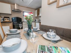 A dining table set with plates and glasses at Swanage Coastal Park Caravan in Swanage