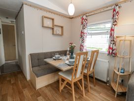 A dining room with a table and chairs at Swanage Coastal Park Caravan in Swanage