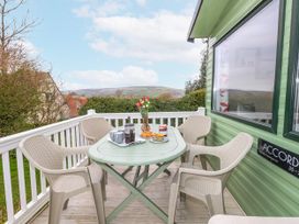 An outdoor seating area with a table and chairs at Swanage Coastal Park Caravan in Swanage