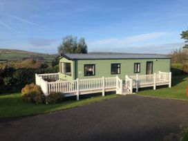 A caravan with decking and windows at Swanage Coastal Park Caravan in Swanage