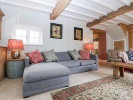 A living room with a sofa and lamp at Velindra Farm Cottage Hereford