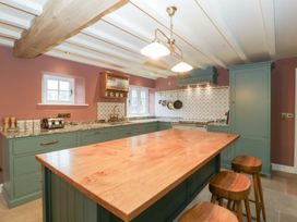A kitchen with a large island and bar stools at Velindra Farm Cottage Hereford