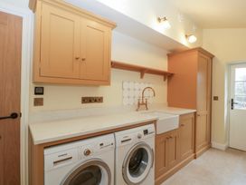 A laundry room with a washing machine and tumble dryer at Velindra Farm Cottage Hereford