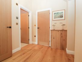 A hallway with wooden doors and a console table at Velindra Farm Cottage Hereford