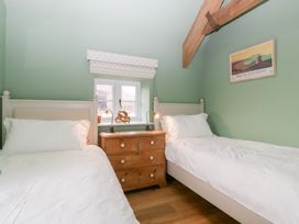 A bedroom with two beds and a dresser at Velindra Farm Cottage Hereford