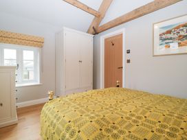A bedroom featuring a bed, wardrobe, and window at Velindra Farm Cottage Hereford