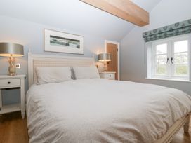 A bedroom with a bed, nightstands, lamps, and a window at Velindra Farm Cottage Hereford