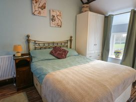 A bedroom with a bed and wardrobe at Fullers Studio in Caergeiliog