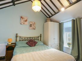 A bedroom with a bed and wardrobe at Fullers Studio in Caergeiliog