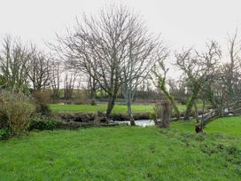A landscape with trees and a stream at The Mill in Holyhead