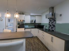 A kitchen with a countertop, cabinets, and appliances at Ty Crigyll in Holyhead
