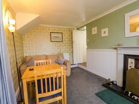 A living room with a sofa and dining table at Ty Crigyll in Caergeiliog