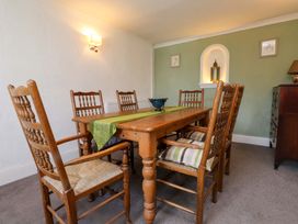 A dining room with a wooden table and chairs at Ty Crigyll in Caergeiliog