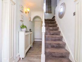 A hallway with a staircase and a plant at Ty Crigyll in Caergeiliog