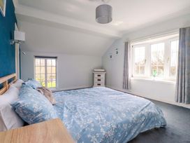 A bedroom with a bed and dresser at Ty Crigyll in Caergeiliog