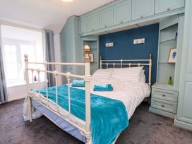 A bedroom with a bed and bookshelf at Ty Crigyll in Caergeiliog