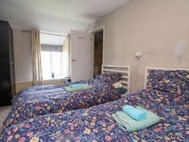 A bedroom with two beds and towels at Ty Crigyth in Caergeiliog