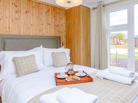A bedroom with a bed and tray of beverages at The Alwalton in Kings Cliffe