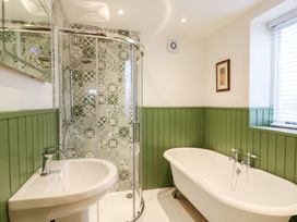 A bathroom with a shower, bath tub, and sink at Lake View in Crediton