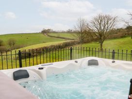A hot tub with a view of hills and trees at Lake View in Crediton