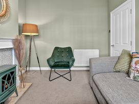 A living room with a green armchair and grey sofa at Windsor House York