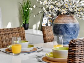 A dining room with a table set for breakfast including a vase with flowers at Windsor House in York