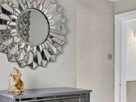 A hallway with a mirror and decorative object on a console table at Windsor House, York
