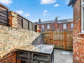 A garden with a table and chairs surrounded by brick walls at Windsor House in York