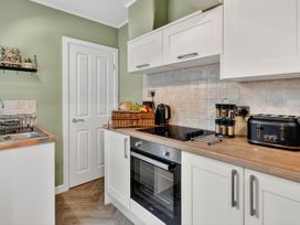 A kitchen with a sink, oven, and storage basket at Windsor House in York
