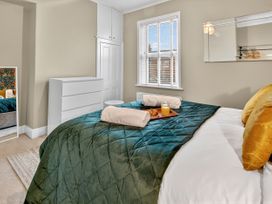 A bedroom with a bed and dresser at Windsor House in York