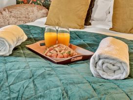 A bedroom with a tray of food and drinks on the bed at Windsor House in York